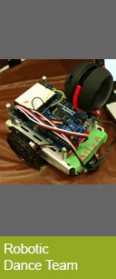 Small wheeled robot with wires and headphones, labeled as part of a "Robotic Dance Team," designed for Research and experimentation in robotics.