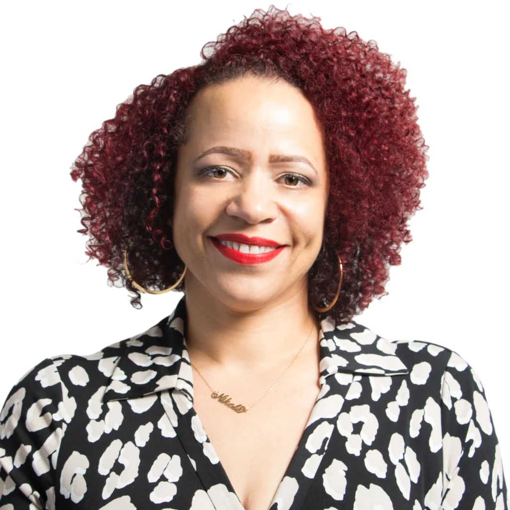 Smiling woman with curly red hair, hoop earrings, red lipstick, and a patterned black and white shirt at the Martin Luther King Jr. Celebration in Valpo.
