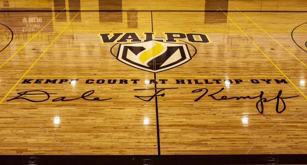 Valparaiso basketball court with "Kempf Court at Hilltop Gym" and a large signature on the wood floor, showcasing recent renovation made possible by the Kempf Estate.