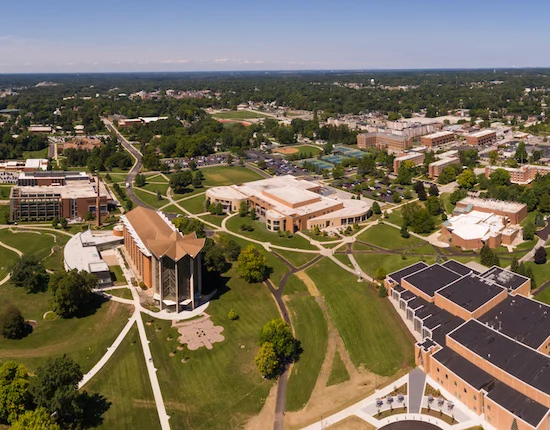 Aerial view of Valparaiso University’s large campus in the Midwest, featuring multiple buildings, green lawns, and walkways on a sunny day.