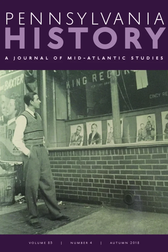 A man in vintage attire stands outside a record store with artist biography posters in the window, Pennsylvania History cover.