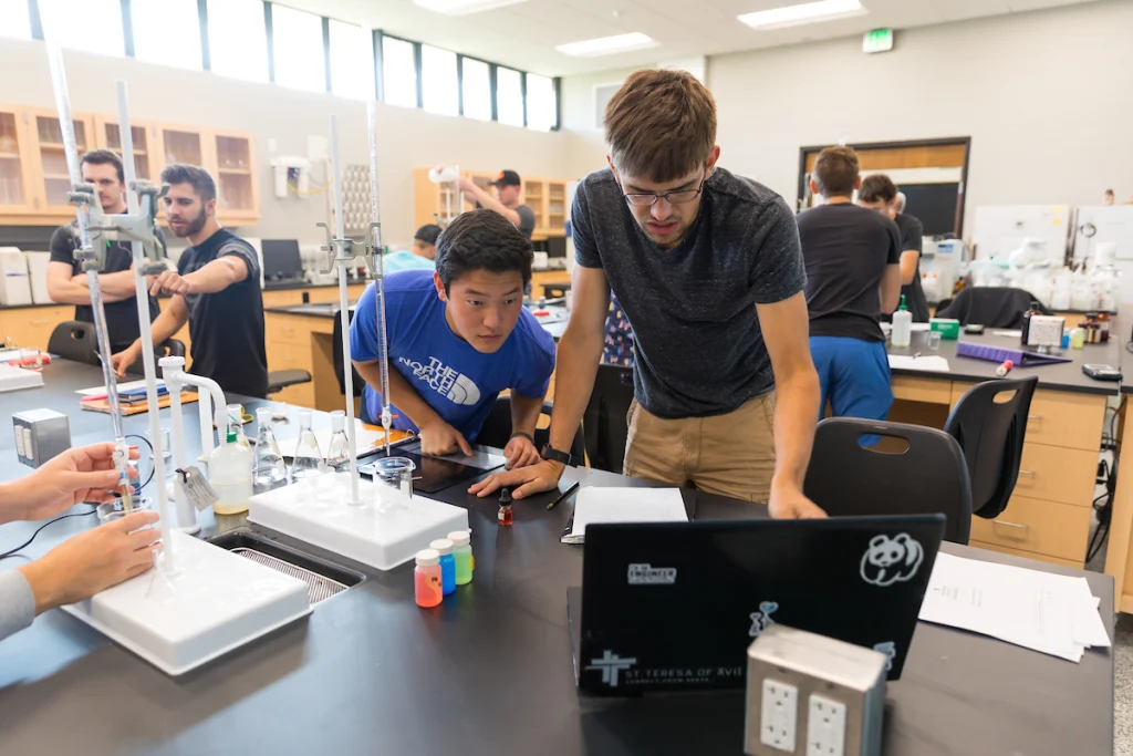 Students work together in the Environmental Engineering Lab, using laptops and laboratory equipment on the tables, demonstrating collaboration and lab dedication.