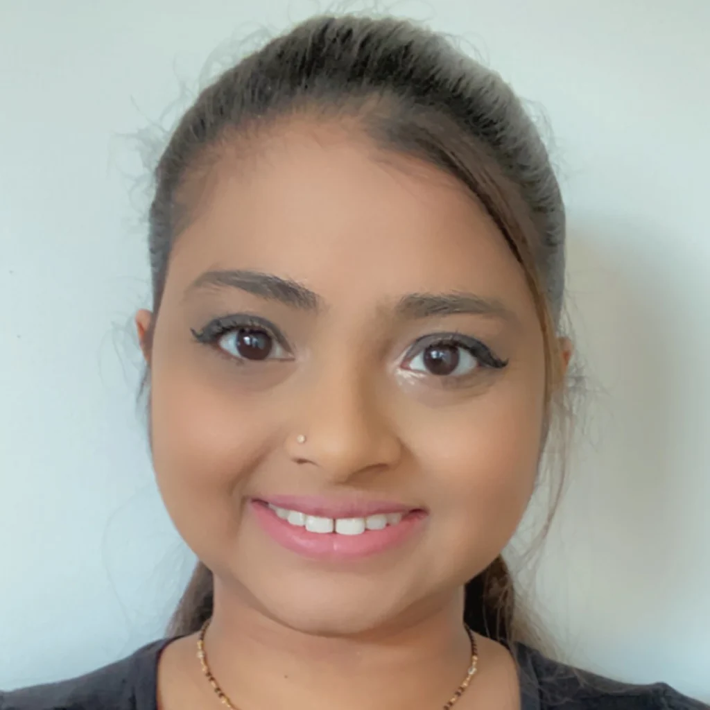 Woman with long dark hair in a ponytail, wearing a black top and a necklace, smiling at the camera—one of the proud Members of the 2020 Class.