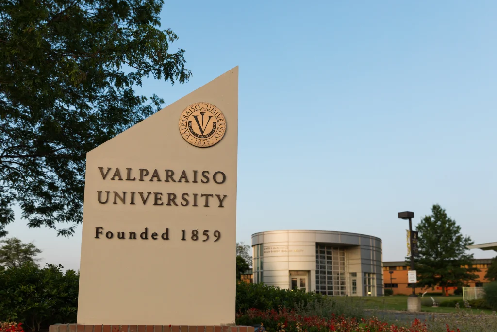 Sign for Valparaiso University, founded 1859, with campus buildings and trees in the background—a standout among the best universities recognized by U.S. News & World Report.