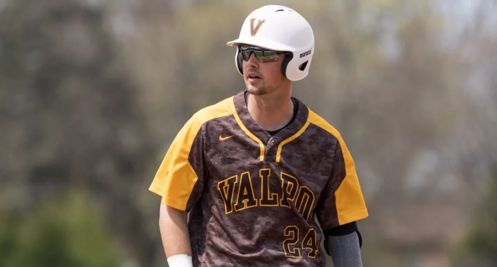 Baseball player in a Valpo uniform and helmet stands outdoors, looking to the side, representing Valpo Student-Athletes who showed resilience during COVID-19.