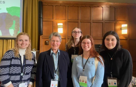 Five smiling women stand indoors at a CUWiP event, wearing name badges and business casual attire. Brook Burbridge, a Valpo Senior, is among the group.