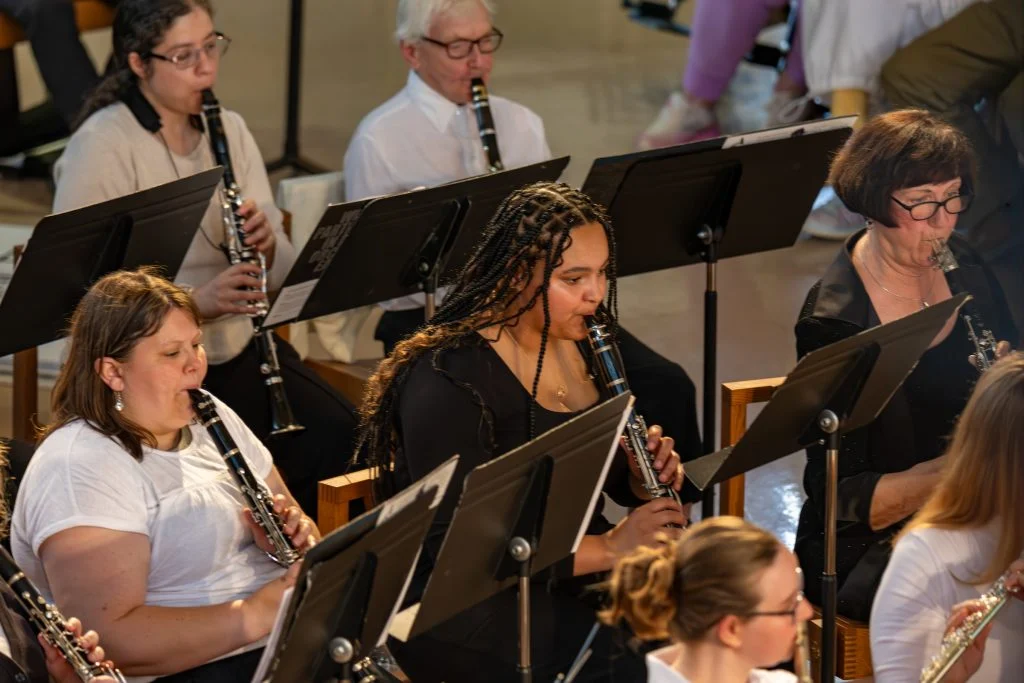 Several musicians play clarinets in an indoor ensemble at The Chapel, seated behind music stands in this serene Way Station of Wonder.