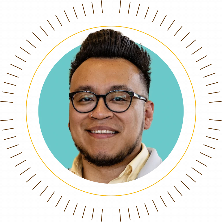 Smiling person with glasses and styled hair, centered in a teal circle with a decorative radiating border, inspires you to shine your brightest—Transfer to Valpo and light up your future.