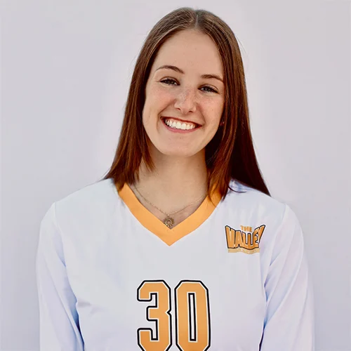 A young woman with straight brown hair smiles at the camera, wearing a white volleyball jersey with the number 30 and "The Valley" logo—meet Biology major Abby Boyle.