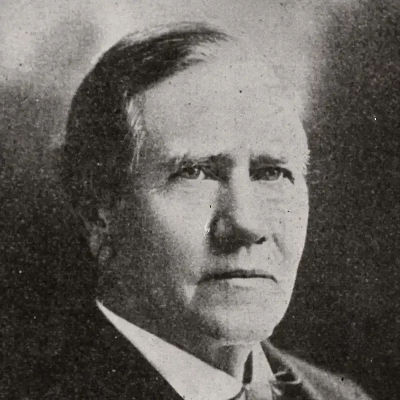Black and white portrait of an older man in a suit, embodying leadership and governance as he looks slightly to the side with a neutral expression.