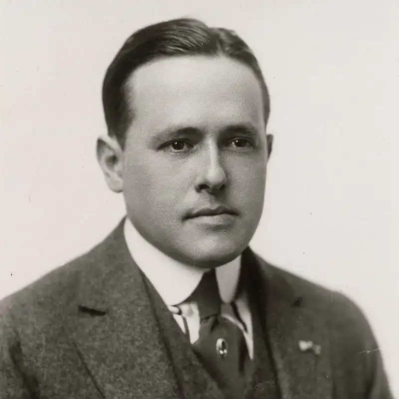 Black and white portrait of a man in a suit and tie, looking directly at the camera—a striking image that embodies leadership and governance.