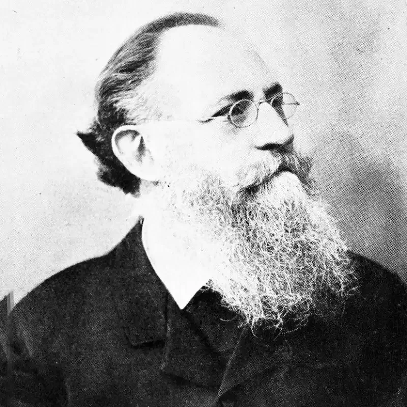 Black and white portrait of an older man with glasses and a long, full beard, looking to the side—a thoughtful expression suggesting wisdom in leadership and governance.