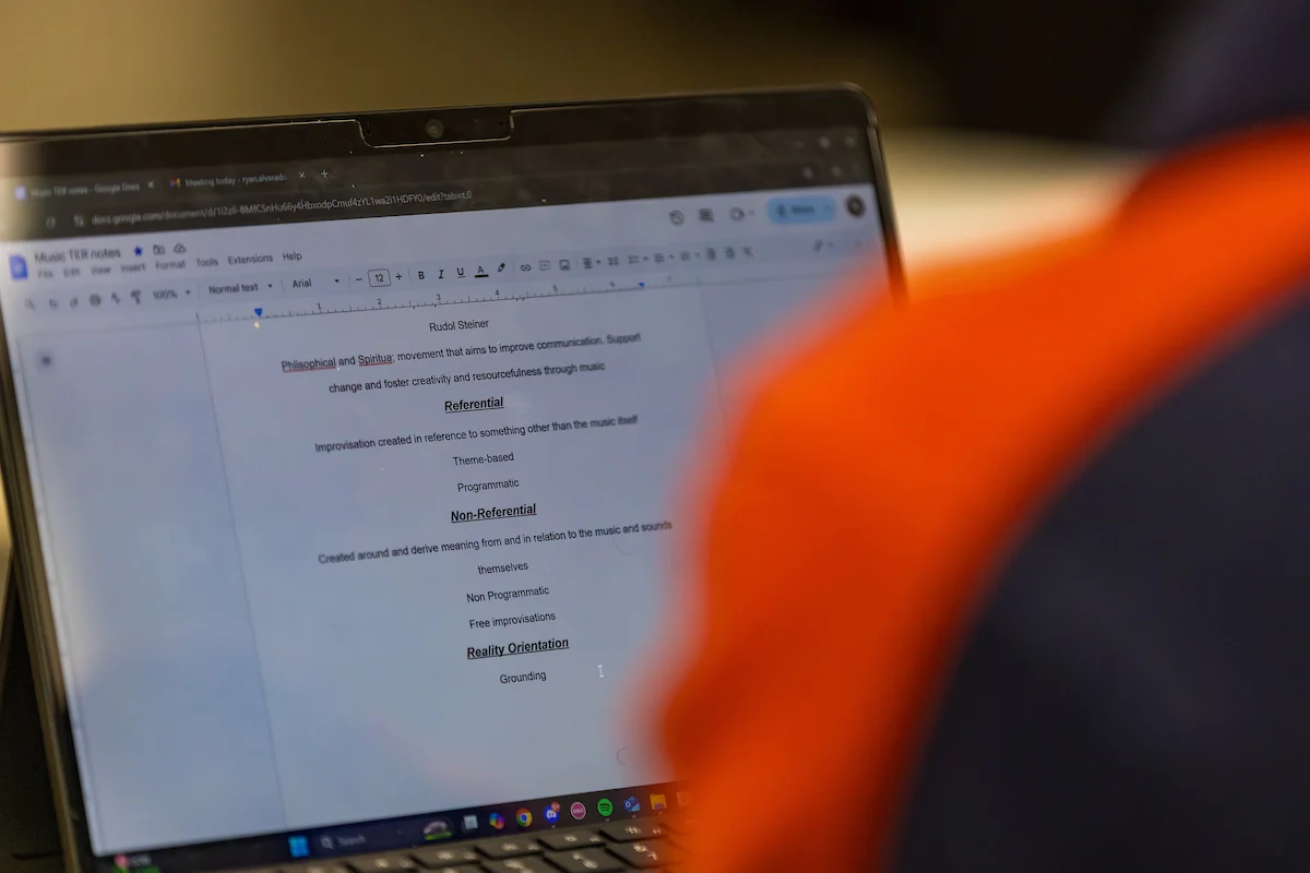A person views a document with bullet points on a laptop screen, exploring transcript services to ensure accuracy and reliability.