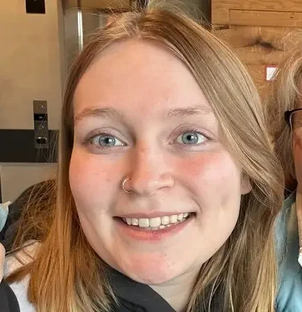 A young woman with straight blonde hair, blue eyes, a nose ring, and a big smile is ready to extend your learning with her bright and positive energy.