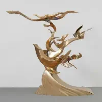 Abstract golden sculpture with sweeping, curved shapes resembling a bird in flight above swirling forms—an elegant centerpiece showcased in renowned exhibitions & series.