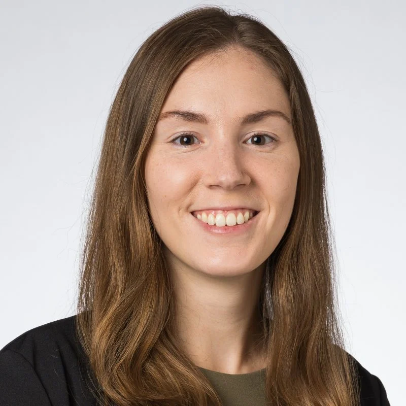 Lauren Sestito, Ph.D., a young woman with long brown hair, smiles at the camera against a plain light background.