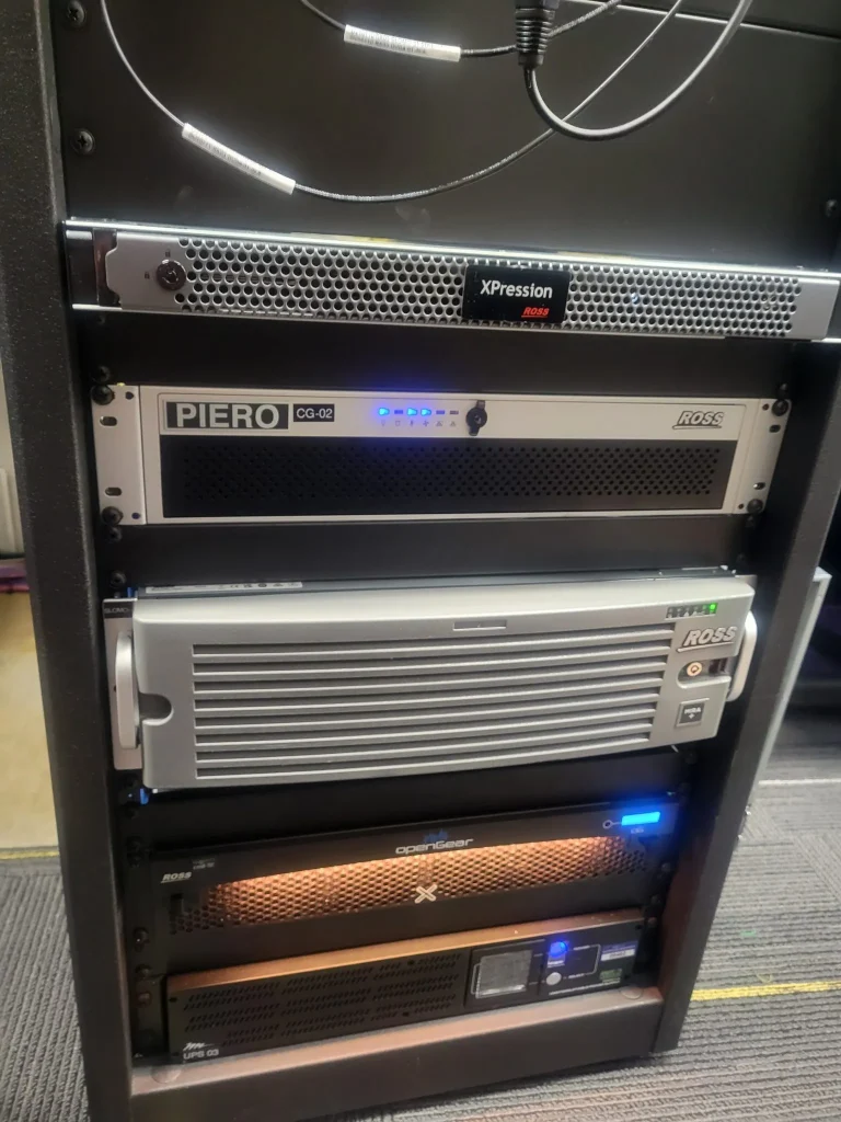 A rack of professional broadcast equipment with various servers and illuminated status lights supports ESPN Valparaiso University Productions.