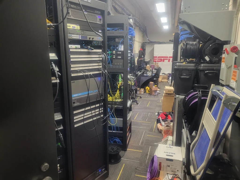 A server room with network racks, cables, boxes, and ESPN Valparaiso University Productions branding in the background.