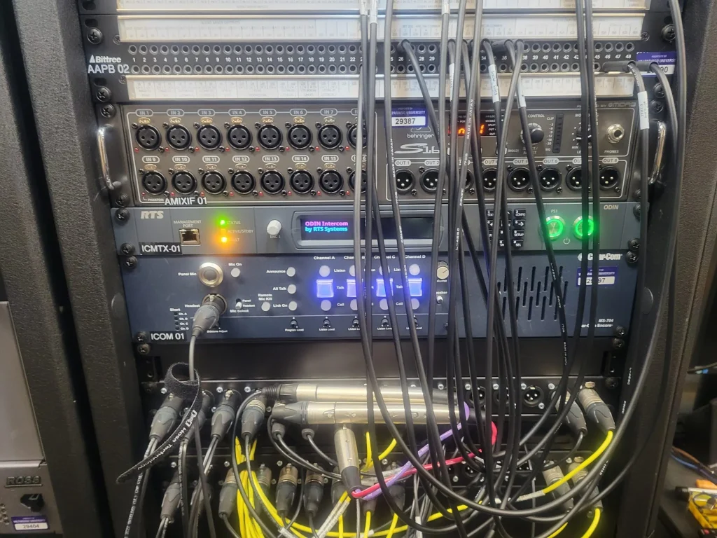 Close-up of a professional audio rack with cables connected to various ESPN Valparaiso University Productions audio and communication equipment.