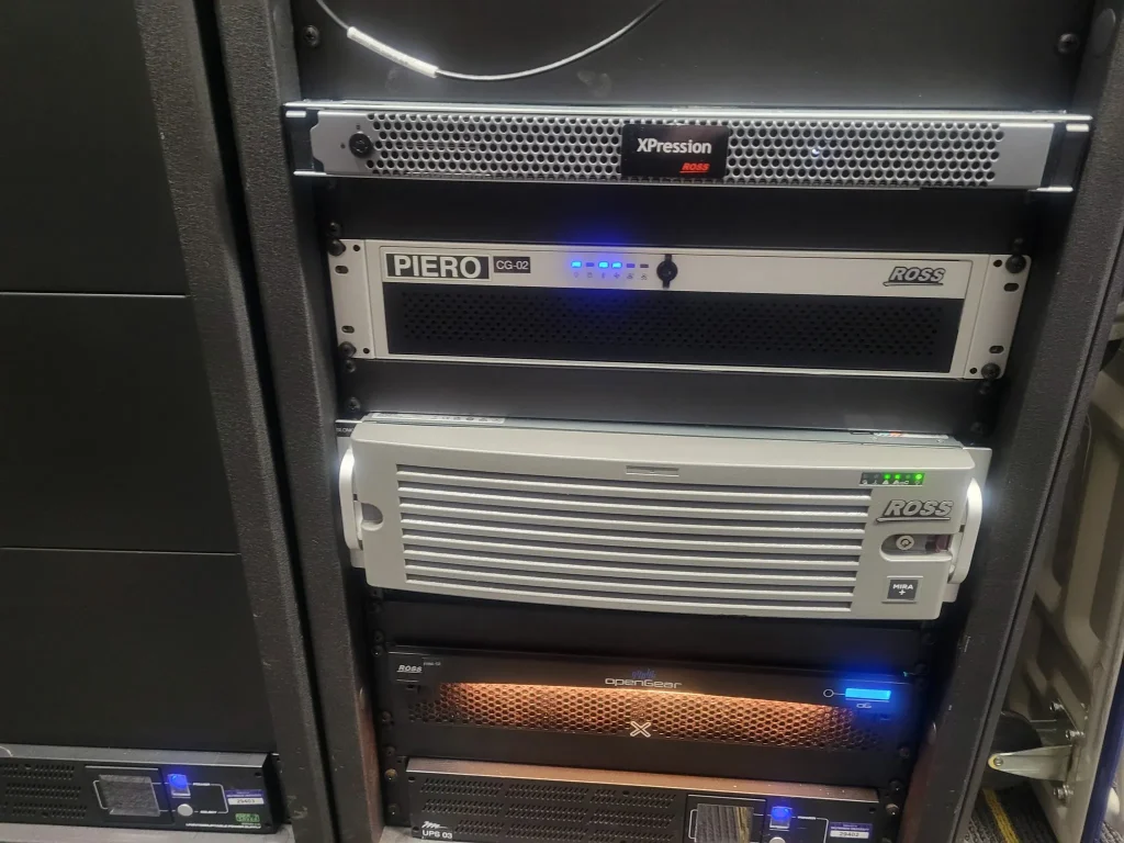 Server rack with multiple equipment units, including Ross and XPression branded devices used by ESPN Valparaiso University Productions, featuring lights and vents.