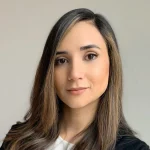 Michelle Van Solt, Ph.D., with straight, light brown hair, wearing a white top and black jacket, looks confidently at the camera.