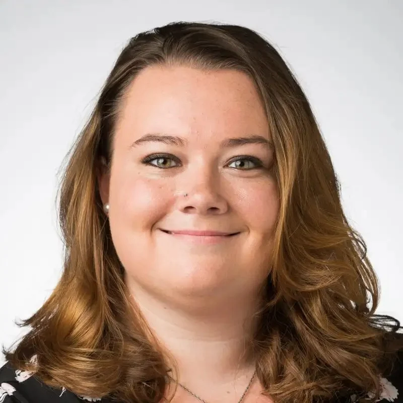 Olivia Gorman, NCC, LMHC, with shoulder-length brown hair, smiles at the camera against a plain light background.