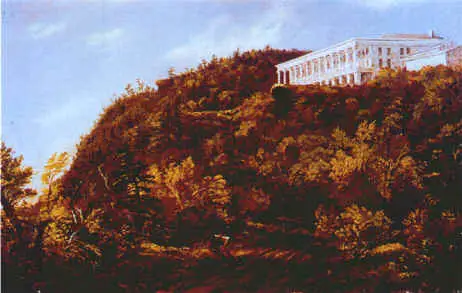A white building with columns, a true American Cultural Icon, sits atop a wooded hill under a blue sky.