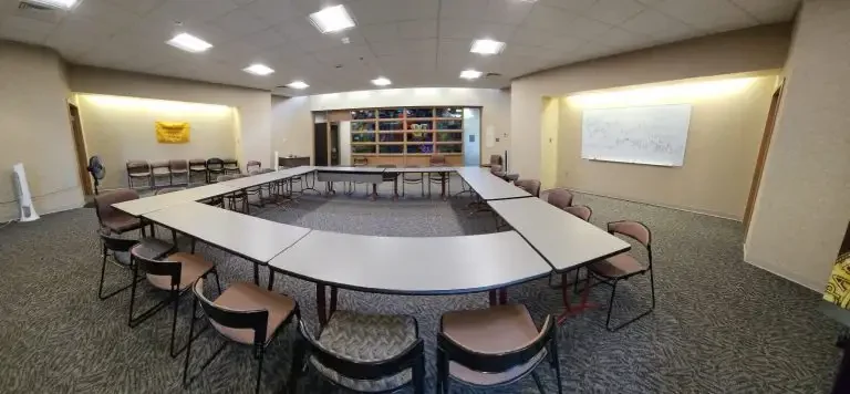 Large conference room in Loke Hall features a U-shaped table arrangement, surrounded by chairs and a whiteboard on the wall.